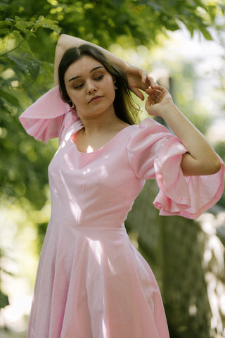 Blossom Dress – close-up side view – round neckline, puff sleeves with flared cuffs, fitted waist, flared skirt, pink cotton – Cori Tailor