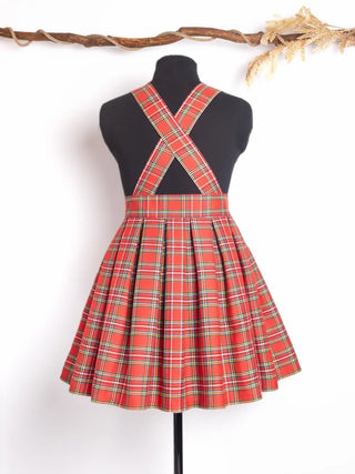 Back view of the Jenny Skirt – red tartan suspender skirt with box pleats and crossed straps, handmade in a vintage schoolgirl style by Cori Tailor.