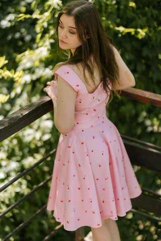 Back view of model wearing Lolita Set cherry pink gingham set with V-back crop top and flared skirt — Cori Tailor summer collection.