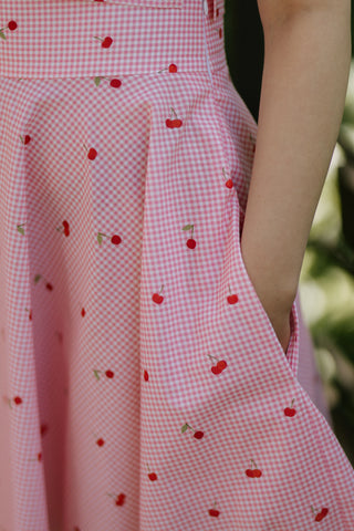Close-up of the Lolita Skirt by Cori Tailor, showing pink gingham fabric with cherry print and side pocket detail
