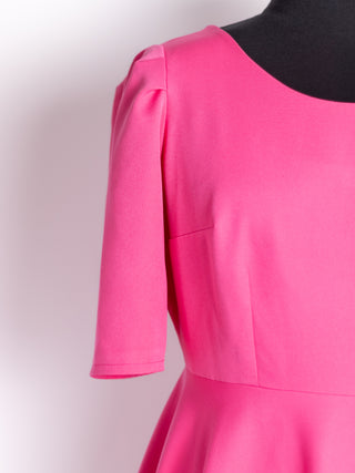 Close-up of the Rose Dress by Cori Tailor in vibrant pink – detailed view of the scoop neckline, structured bodice seams, and mid-length sleeve.