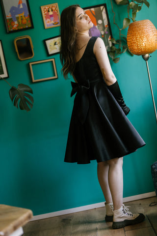 Sabrina Dress – angled back view – sleeveless scoop back, oversized bow at waist, flared skirt, black taffeta – Cori Tailor