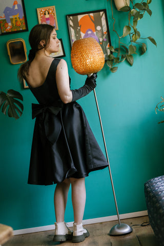 Sabrina Dress – back view – deep scoop back, oversized bow at waist, sleeveless fitted bodice, flared skirt, black taffeta – Cori Tailor