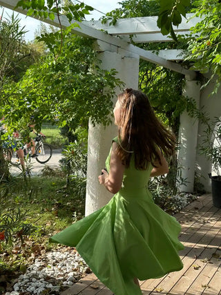 Back view of the Tinkerbell Deux Pièces outfit mid-twirl, showing the flowing handkerchief hem skirt in vibrant green – playful vintage-inspired fashion by Cori Tailor